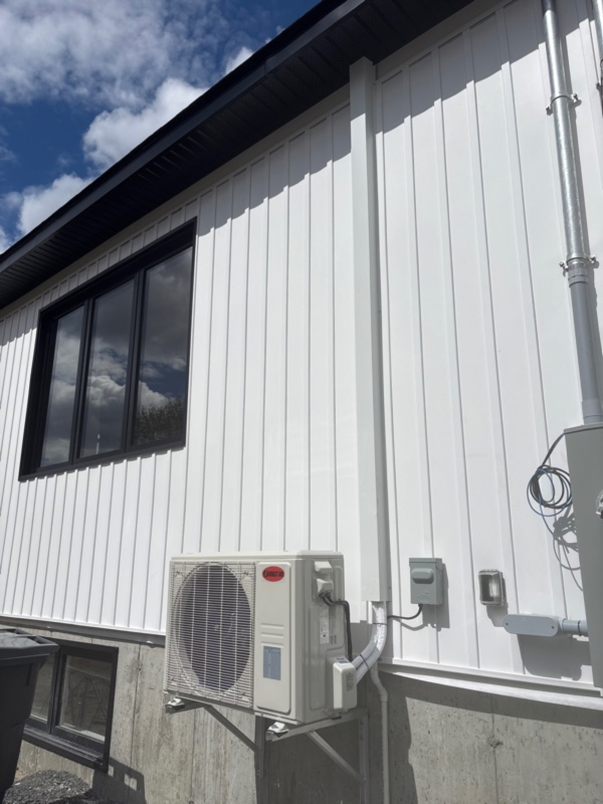 Unité extérieure Direct Air installée sur un bâtiment au revêtement blanc